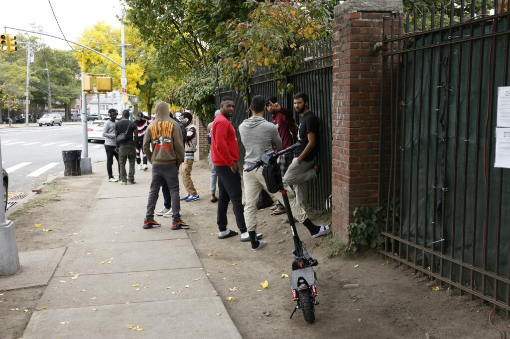 african migrants stand outside migrant 90950514 e1729470223533 q17eBM