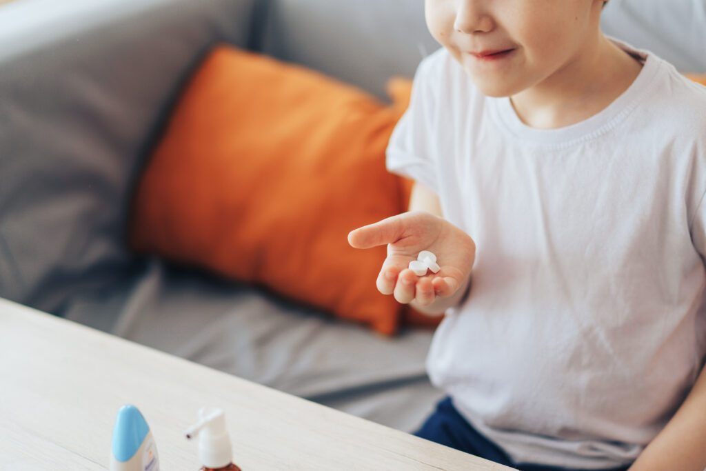 boy holding three round pills 91667804 xL01zP