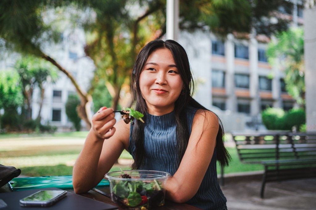 smiling college student girl eating 92144144