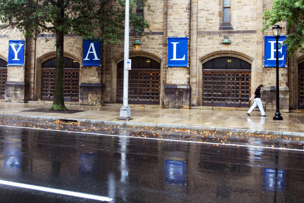 woman walks yale sign reflected 88030668 WNgmJd